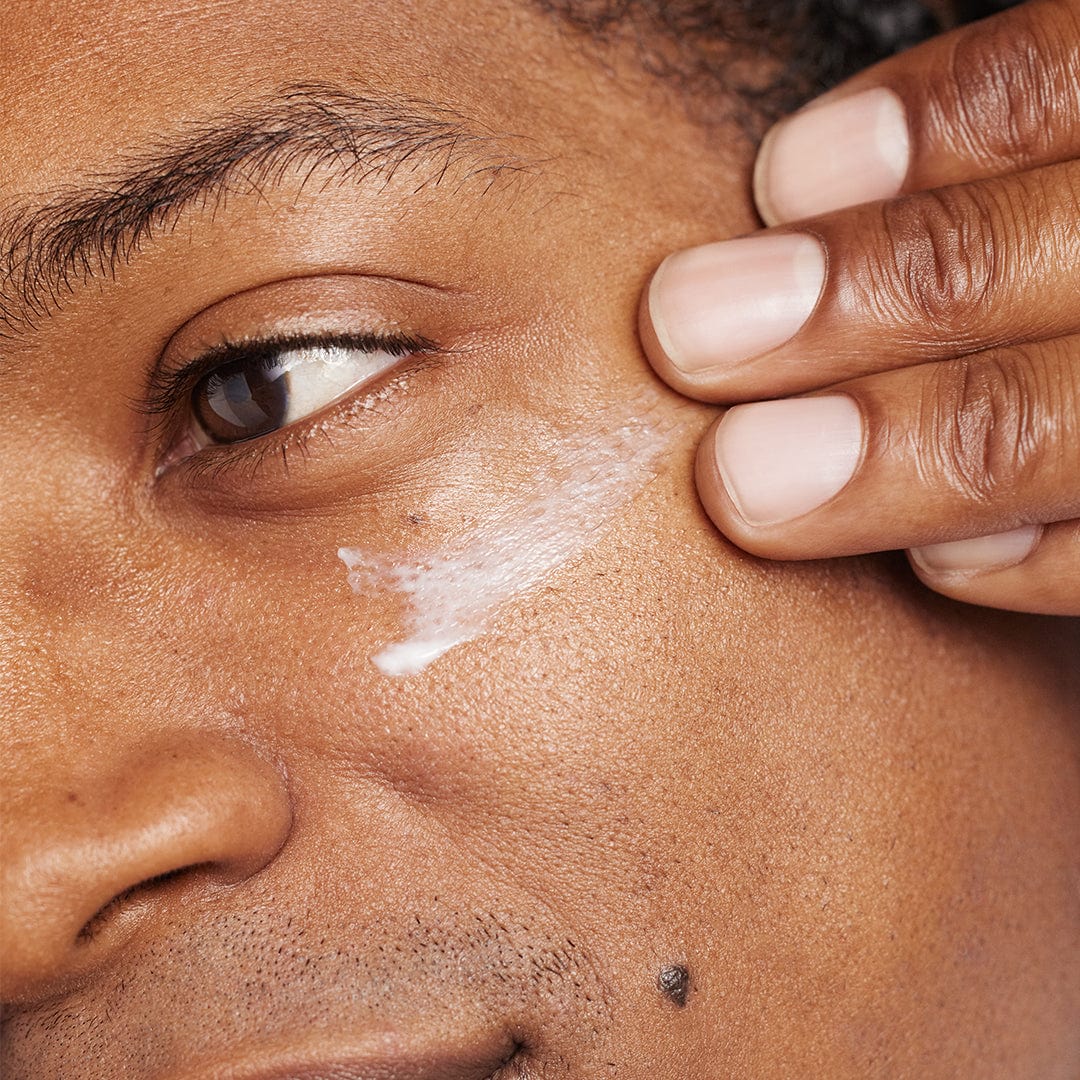Nahaufnahme einer Person, die Phyto Nature Lifting Eye Cream | Augenpflege mit Lifting-Effekt mit den Fingern unter dem Auge aufträgt und sich dabei auf die Hautpflege konzentriert.