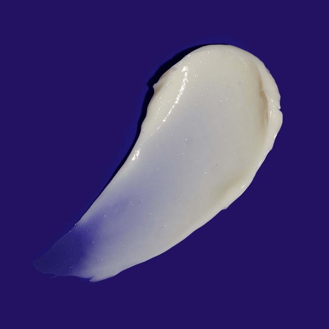 Ein Klecks weiße Phyto Nature Lifting Eye Cream vor einem blauen Hintergrund.